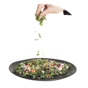 sprinkling bits of salad onto a plate